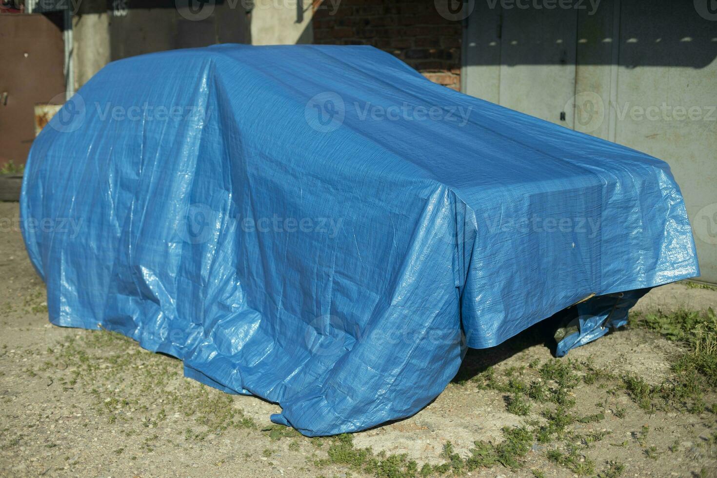 Car is covered with awning. Blue awning on car. Protected vehicles. photo