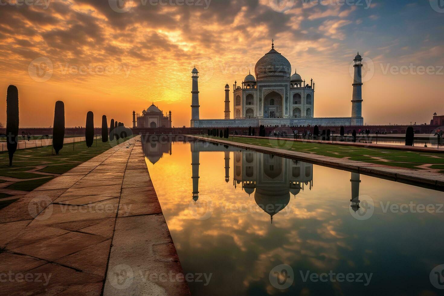 a breathtaking sunset at the iconic Taj Mahal, a magnificent white palace with impressive minarets and domes. The sun's warm hues cast a golden glow on the monument, creating a visually t. photo