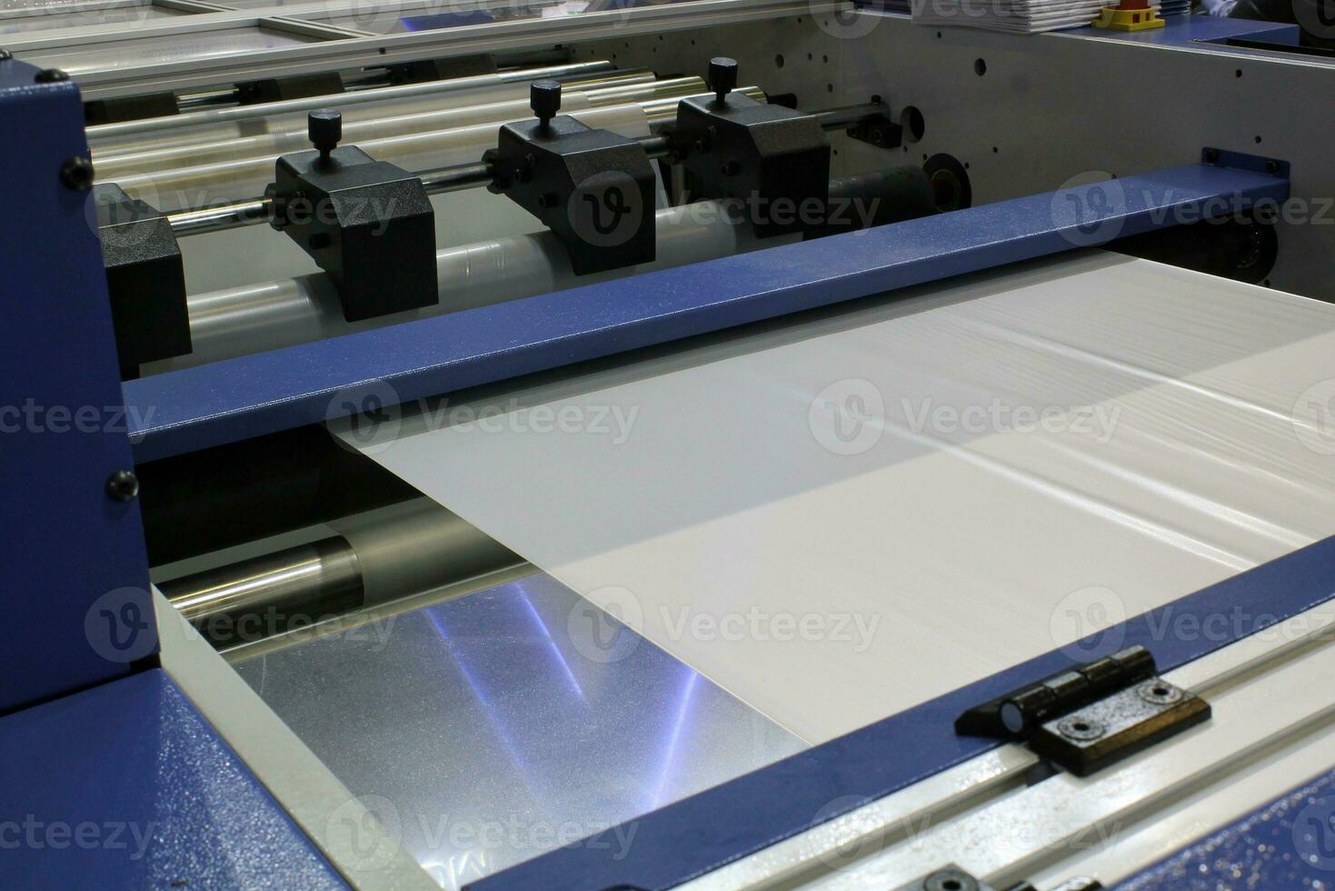 The operation of automatic polyethylene plastic pvc bag production machine. Close-up of roller packaging transparent film. Industrial and technology in factory. Recycling, manufacturing concept photo