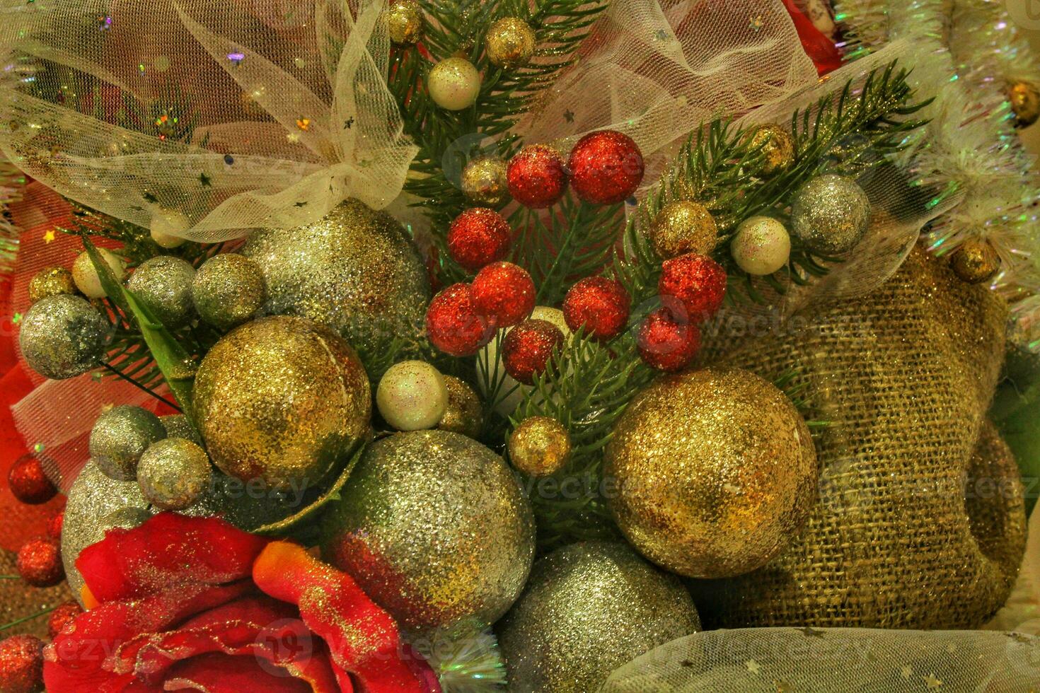 Close-up of Christmas tree in the house with decoration. Garland, lights, baubles and flowers on spruce fir branches. Winter holidays composition photo