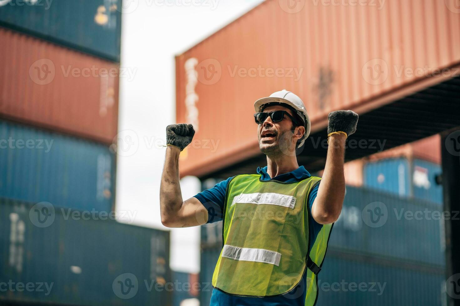 Portrait of Smiling Professional Heavy Industry Engineer Worker Wearing Safety Uniform and Hard Hat. In the Background container Industrial Factory shipment photo