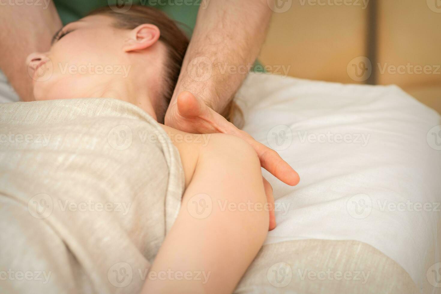 Young caucasian woman having a massage on the shoulder in spa salon. photo