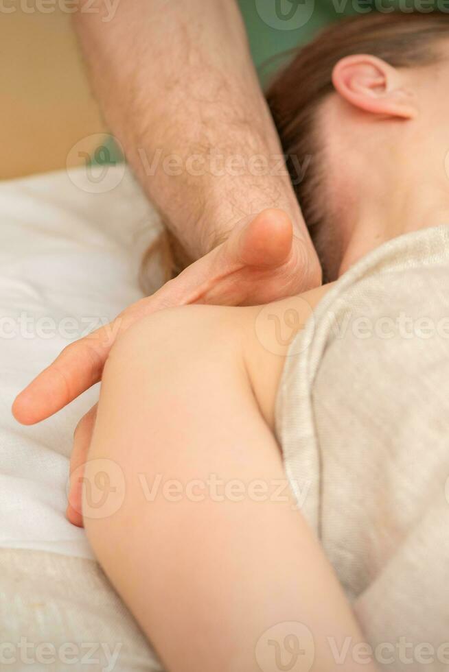 Young caucasian woman having a massage on the shoulder in spa salon. photo