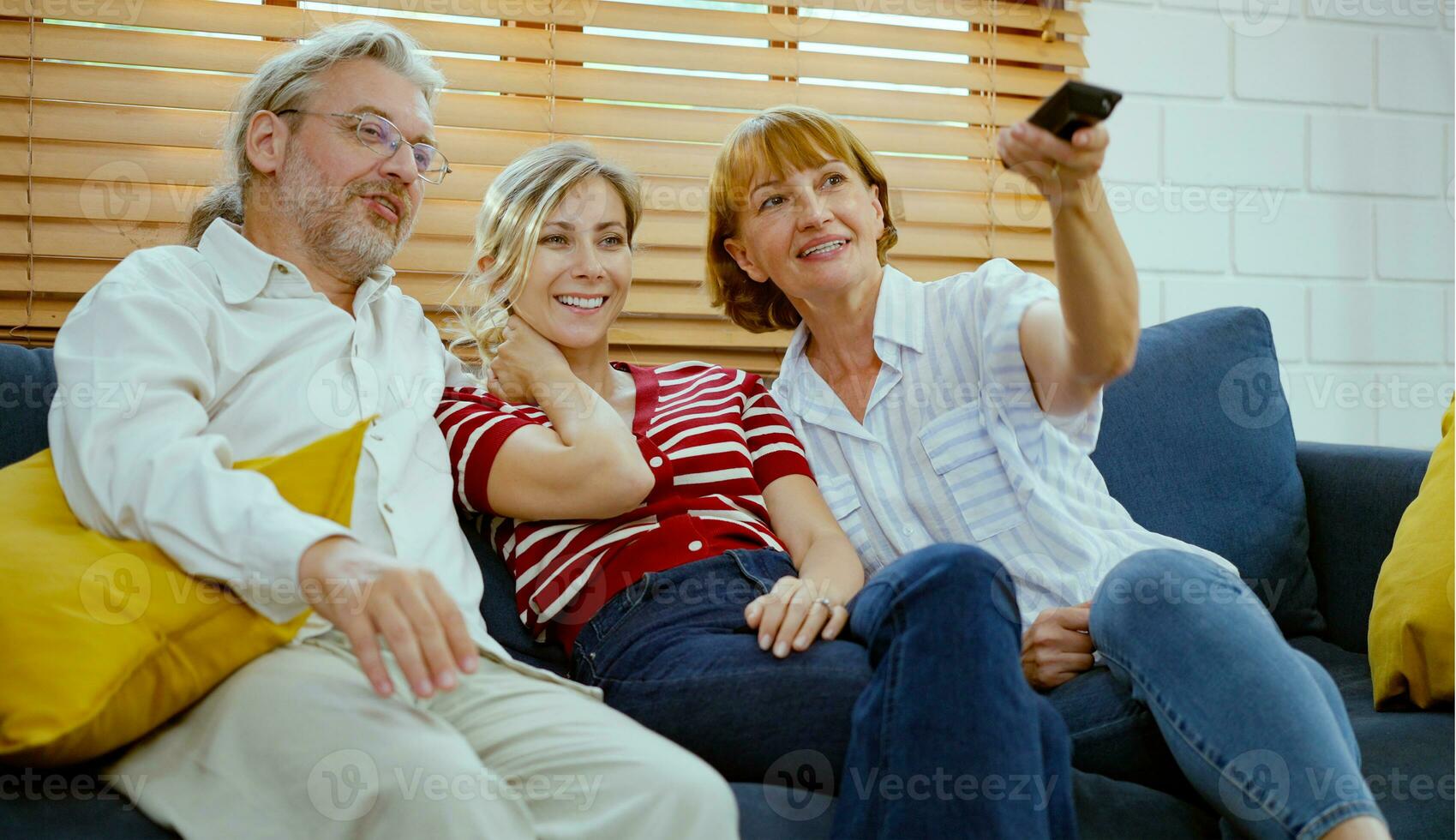 contento familia sentado en sofá y acecho televisión a hogar. foto