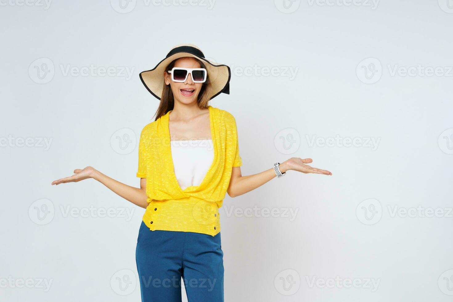 joven mujer vistiendo un Dom sombrero y Gafas de sol, presentación o demostración abierto mano palma con Copiar espacio para producto aislado en blanco antecedentes. foto