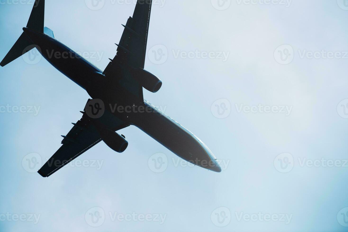 Commercial airplane silhouette seen from below photo