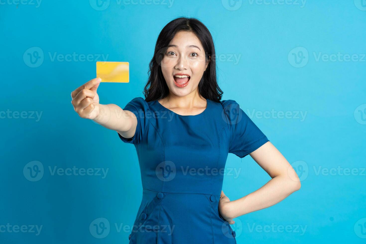 Portrait of beautiful woman in blue dress, isolated on blue background photo