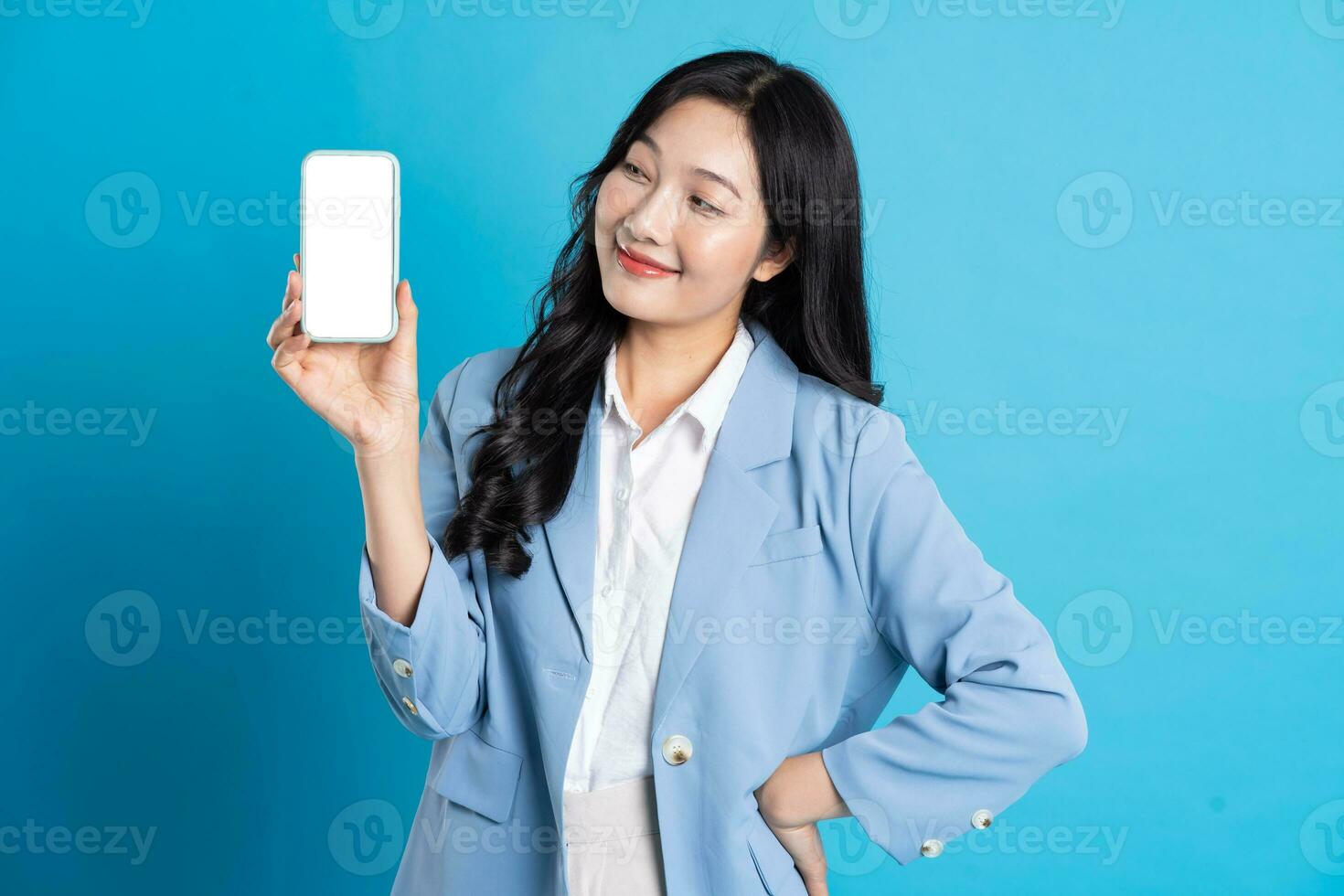 portrait of young asian businesswoman posing on blue background photo