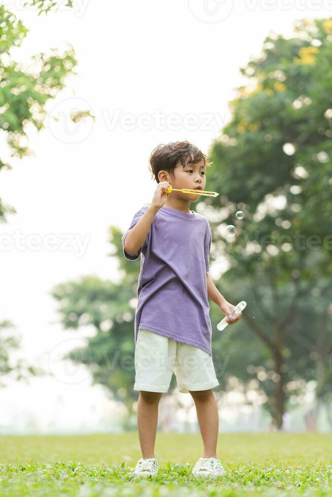 portrait of asian boy playing blowing bubbles photo