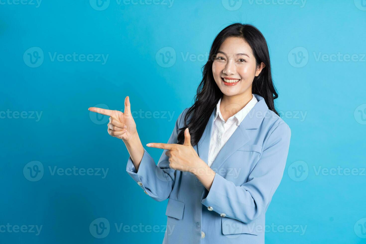 retrato de asiático negocio mujer posando en azul antecedentes foto