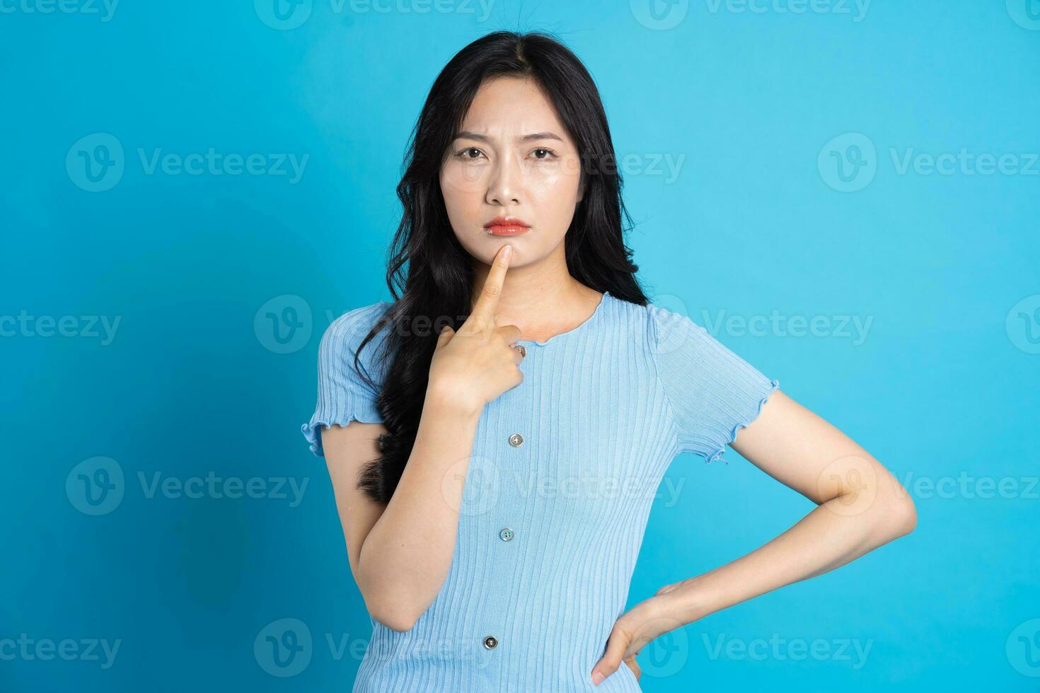 Portrait of a happy smiling asian girl posing on a blue background photo