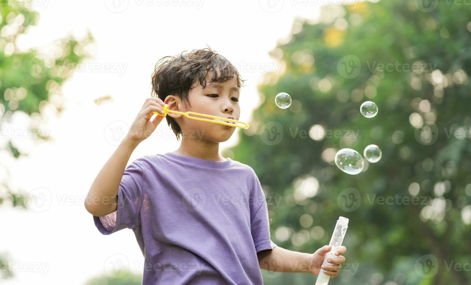 retrato de asiático chico jugando soplo burbujas foto