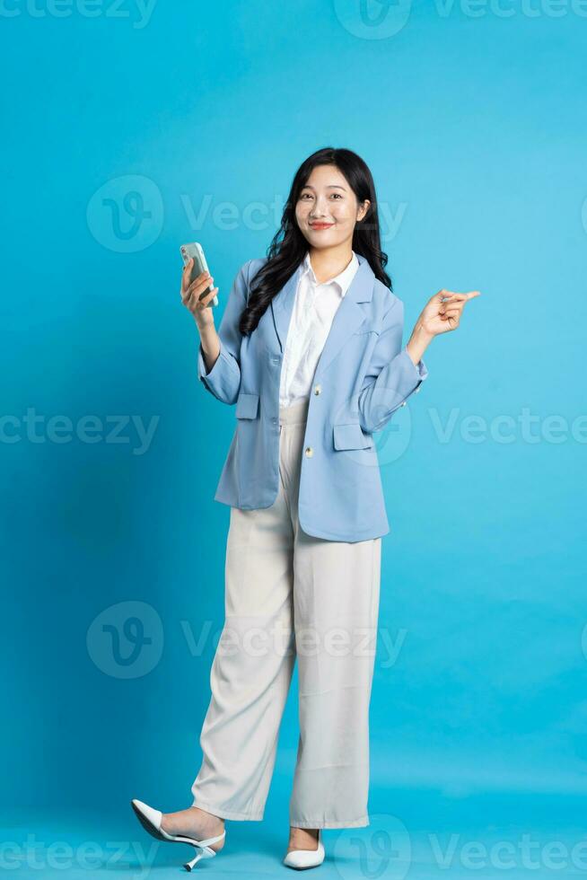 Asian young businesswoman portrait on blue background photo