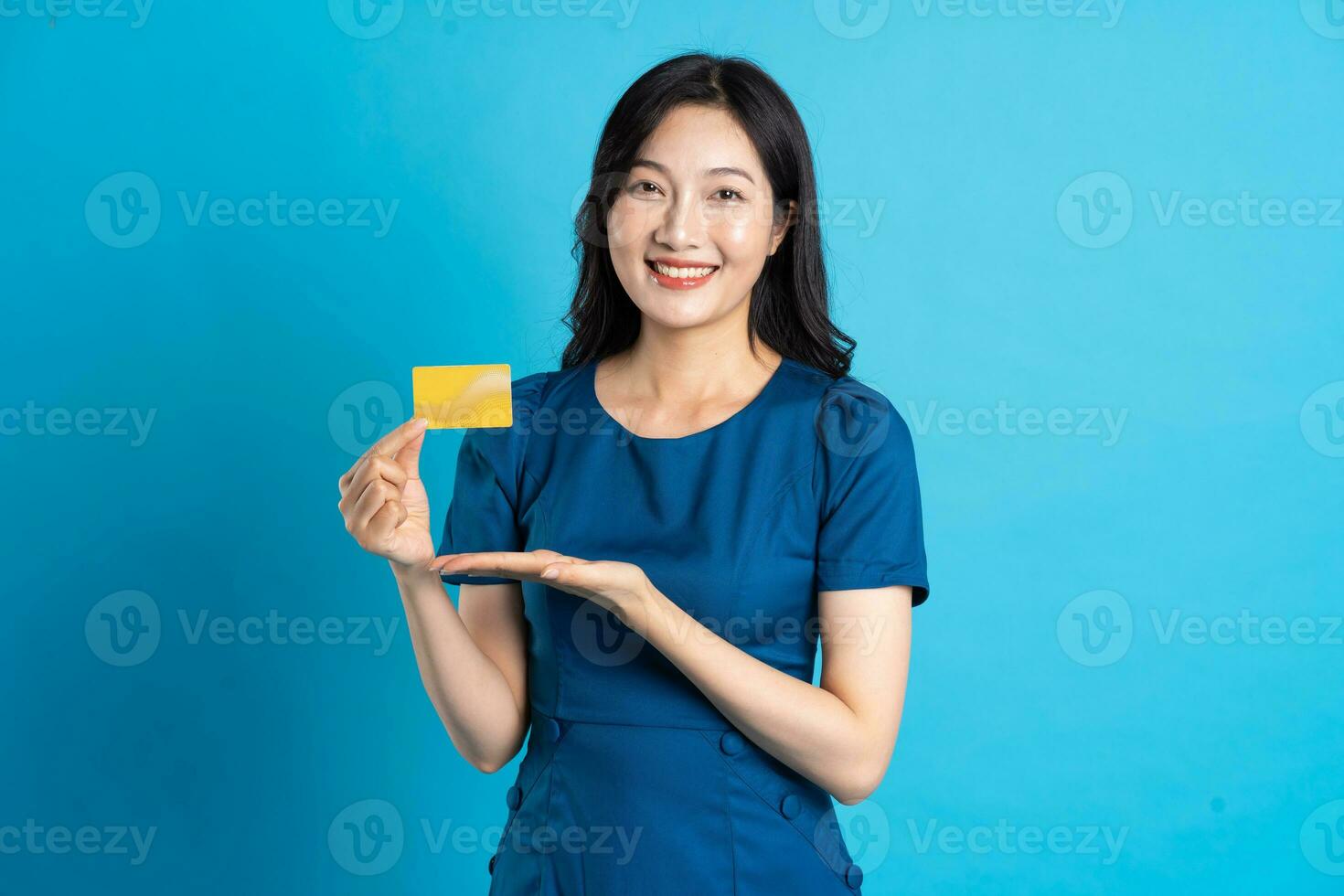 Portrait of beautiful woman in blue dress, isolated on blue background photo