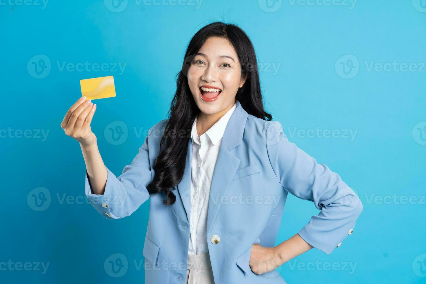 portrait of young asian businesswoman posing on blue background photo