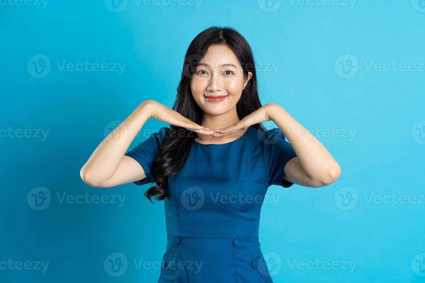 Portrait of beautiful woman in blue dress, isolated on blue background photo
