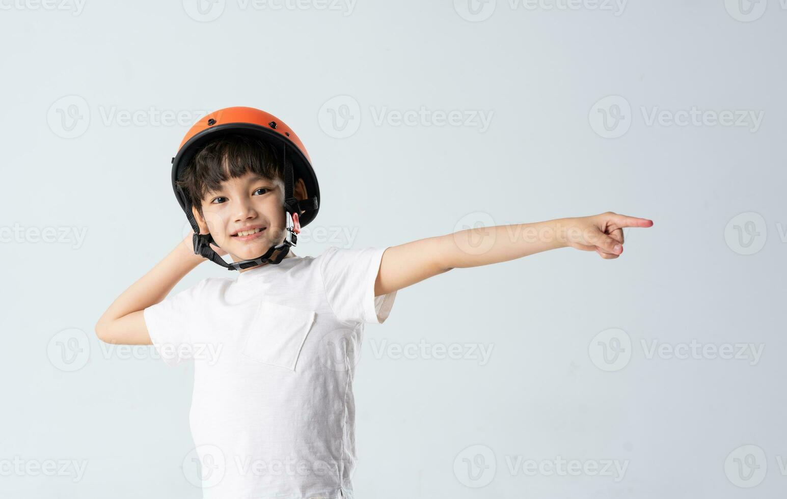 portrait of asian boy wearing orange helmet on white background photo
