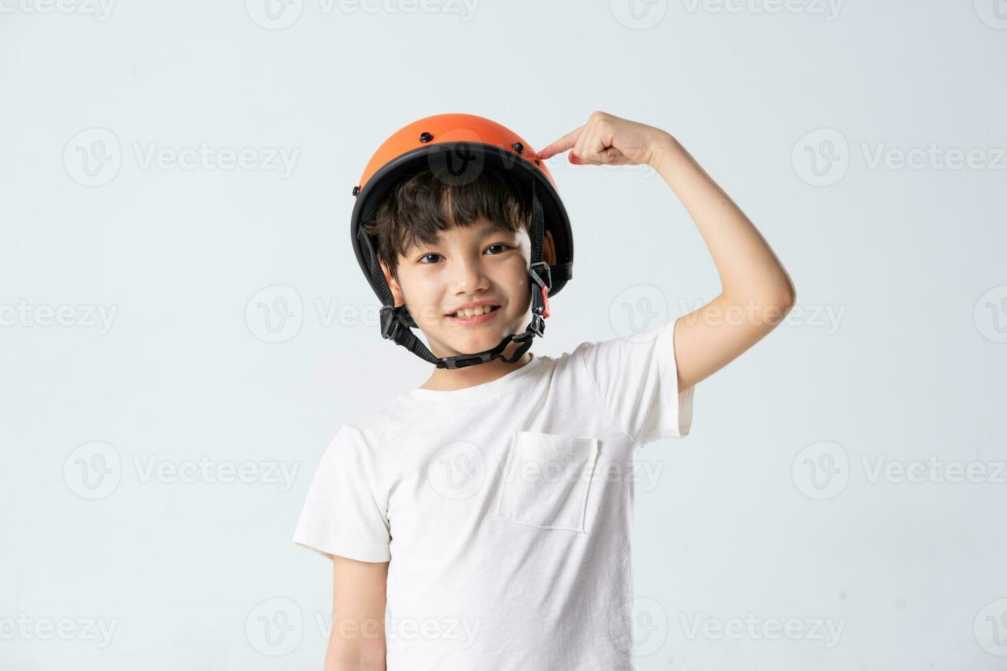 portrait of asian boy wearing orange helmet on white background photo