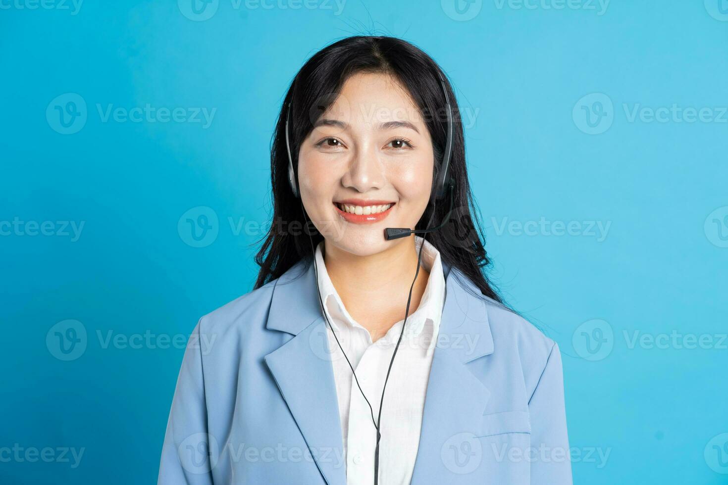 retrato de asiático negocio mujer posando en azul antecedentes foto