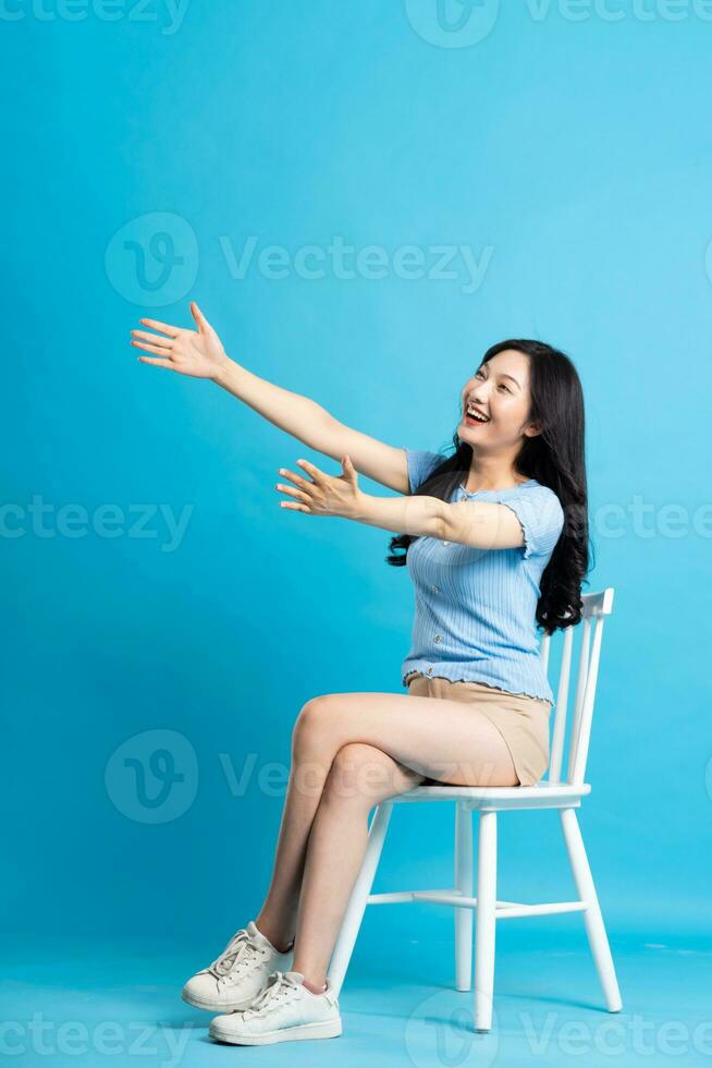 Portrait of smiling asian woman posing on blue background photo