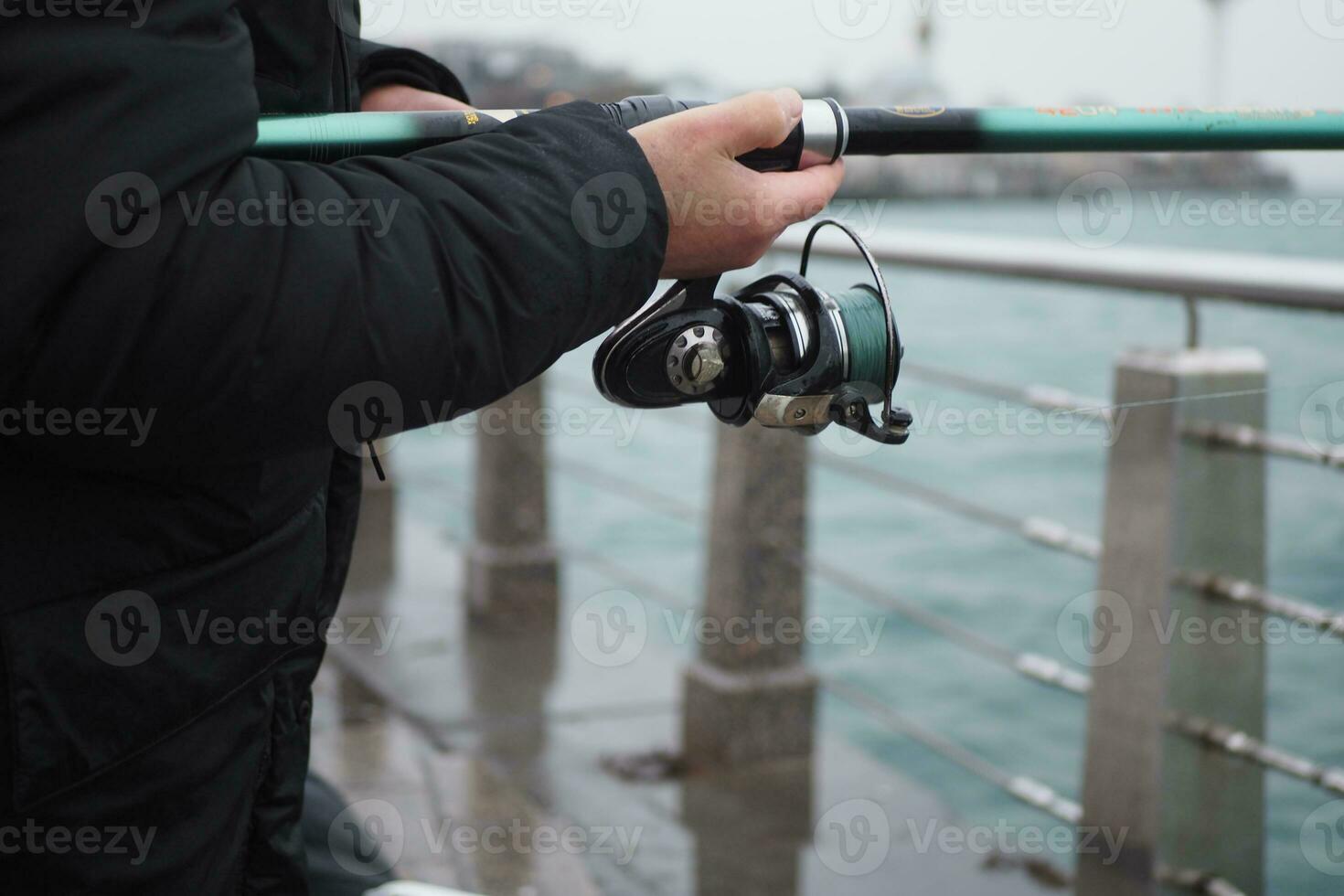 Fisherman with rod, spinning reel , photo