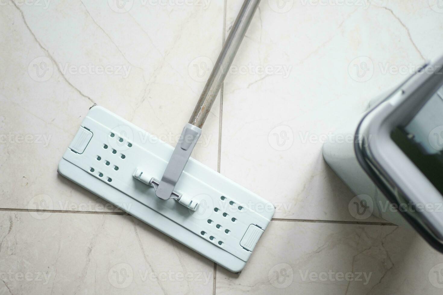 cleaning tiles floor with mop photo