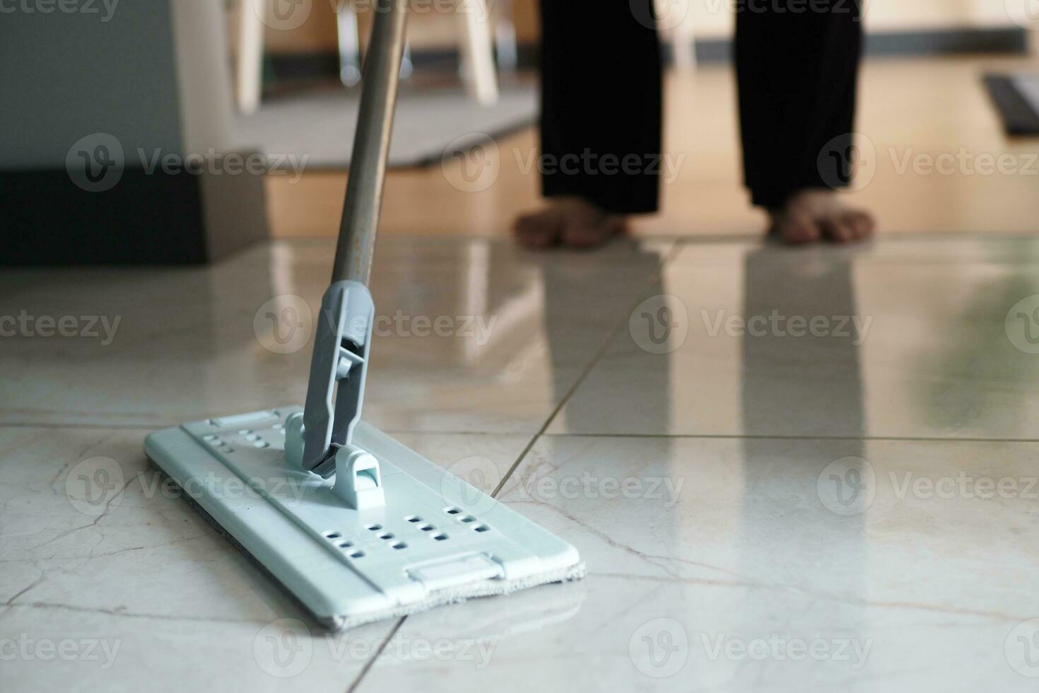 cleaning tiles floor with mop photo