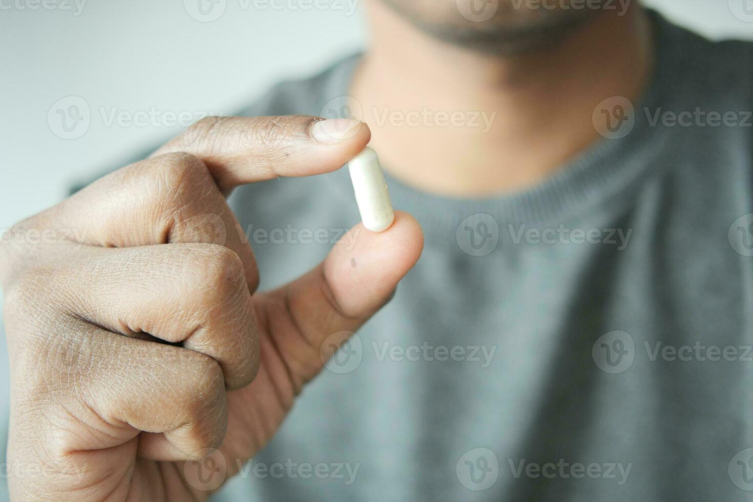 Close up of man hand holding capsule photo