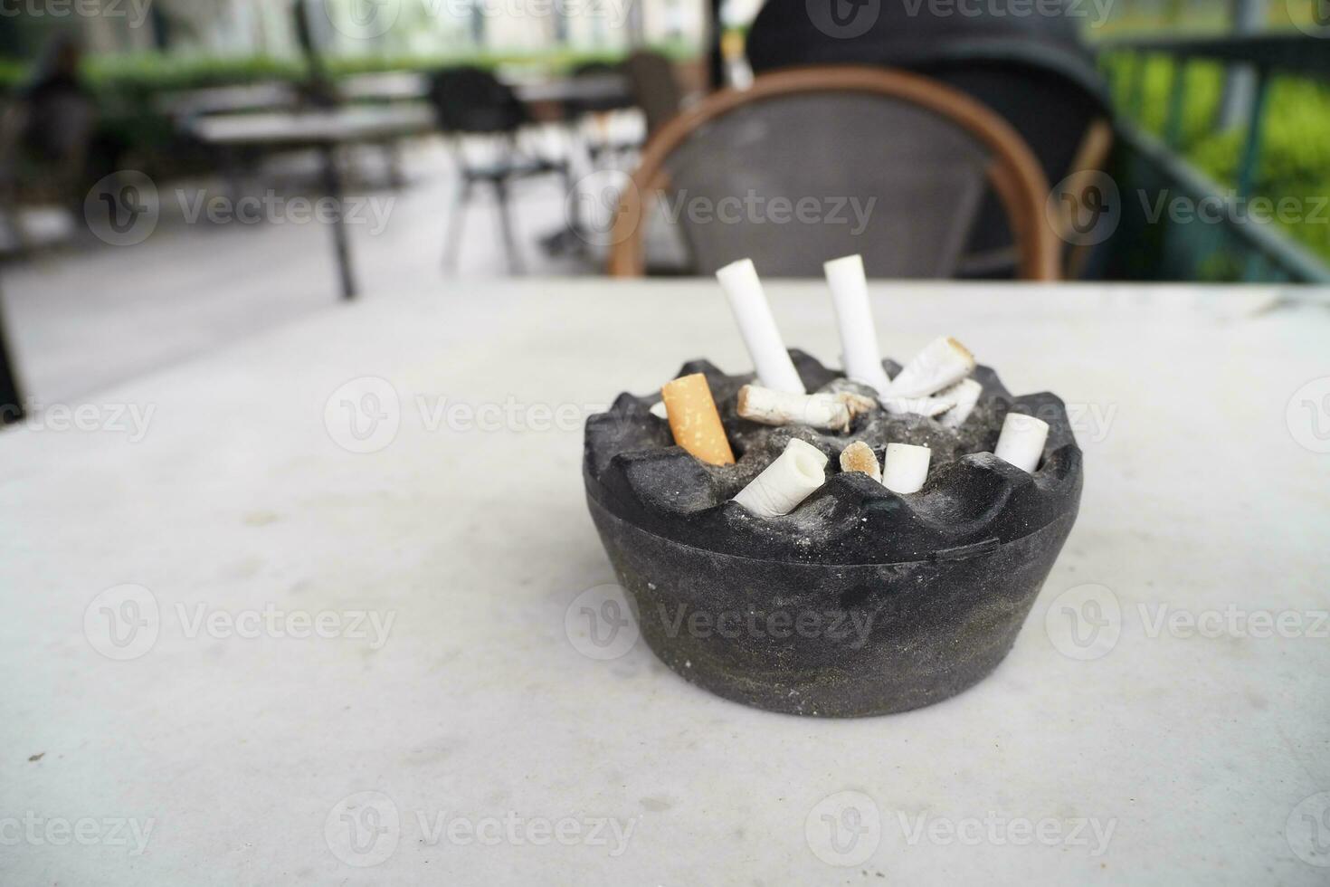 Close up burning cigarette in ashtray on table photo