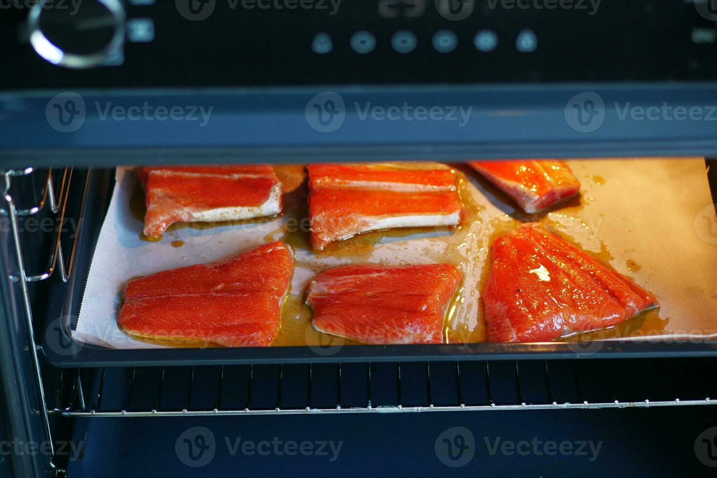 baked salmon fish in open electric oven at home photo