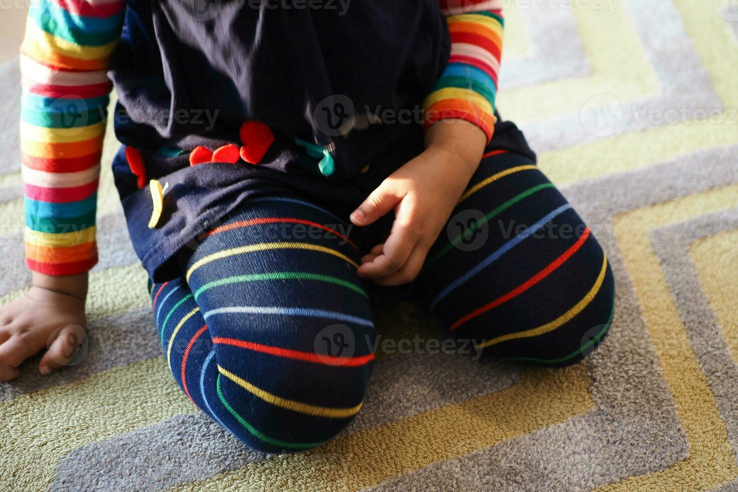 child sitting W posture on the floor . photo
