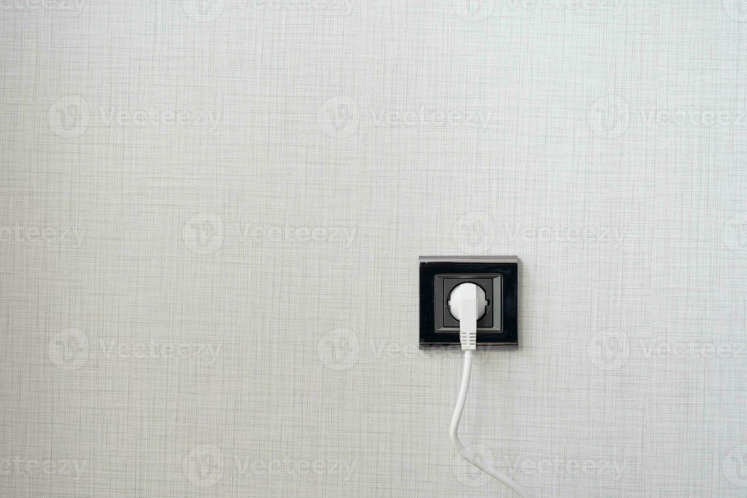 white color power cord cable plugged into wall photo