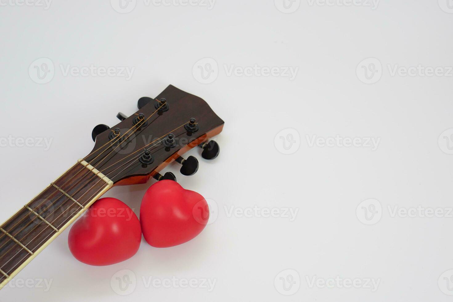 Acoustic guitar neck and red heart against white background. Love, relax and music concept. photo