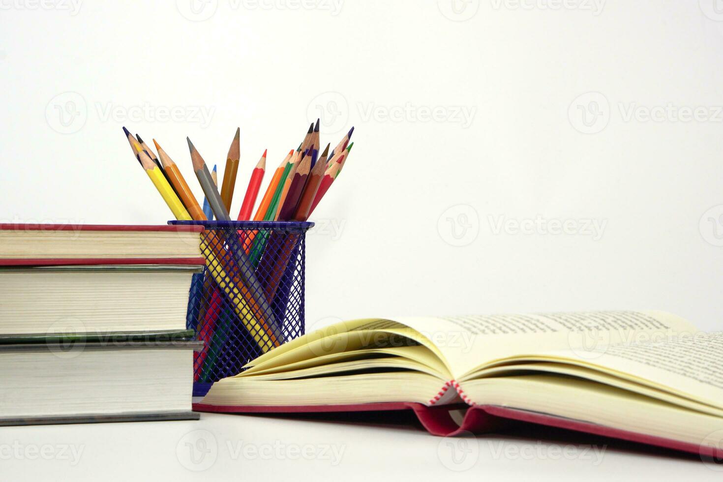 Crayon or colored pencils in box and the book placed in the blurred background. Knowledge and education concept. photo