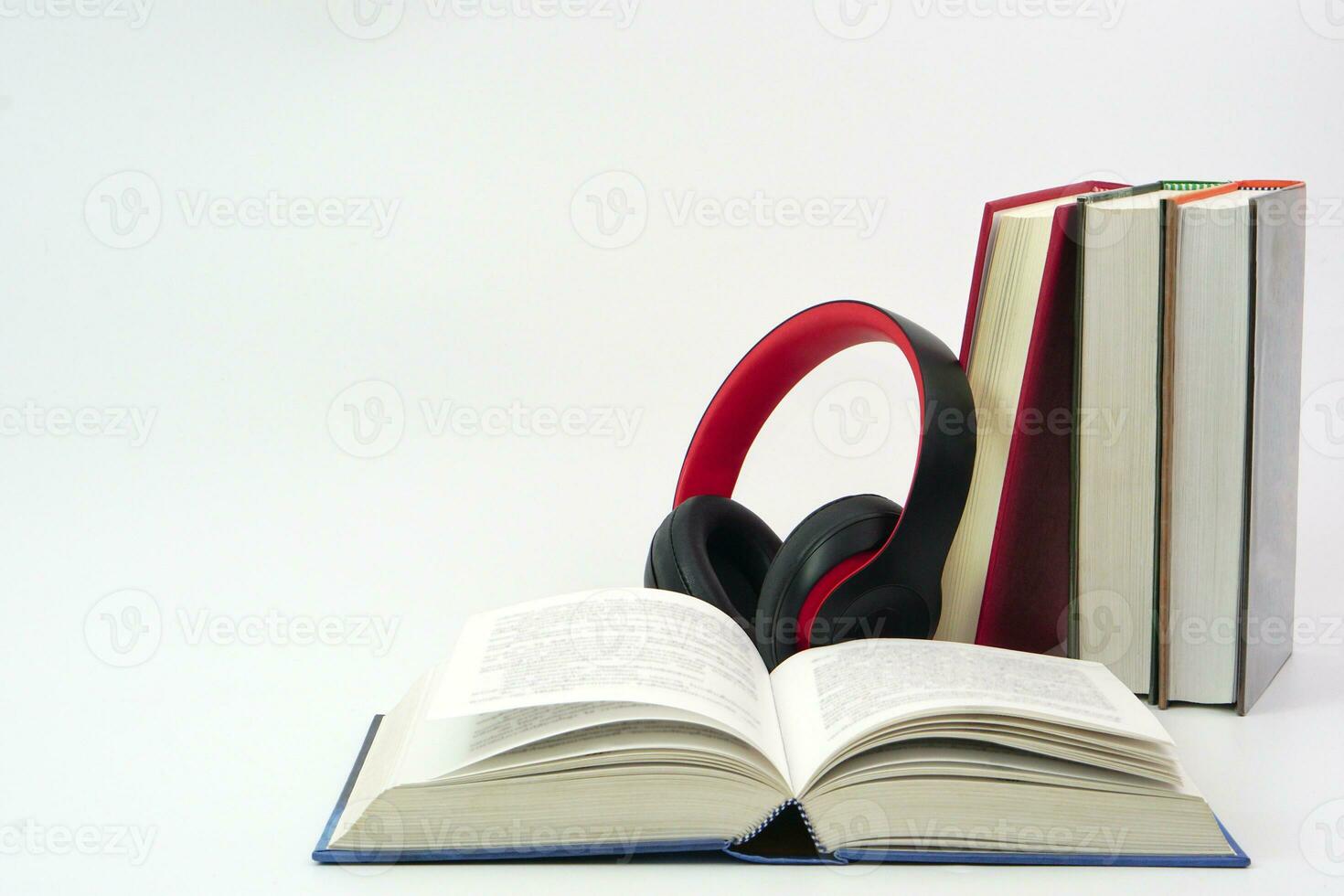 The headphones placed on top of the lined up books. Knowledge, learning and education concept. photo