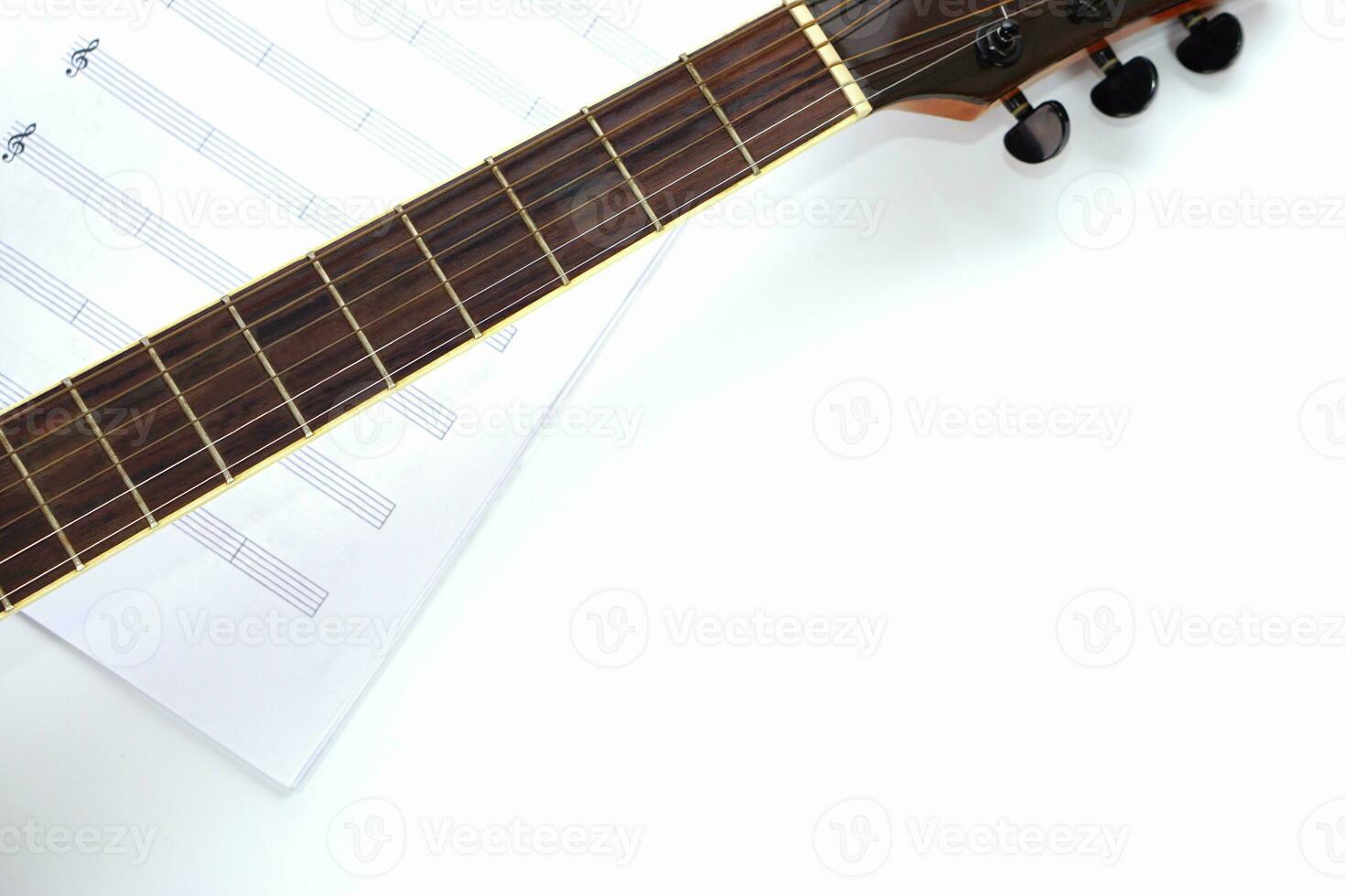Focus the acoustic guitar neck and blur musical notes on white background. Love, music and learning concept. photo