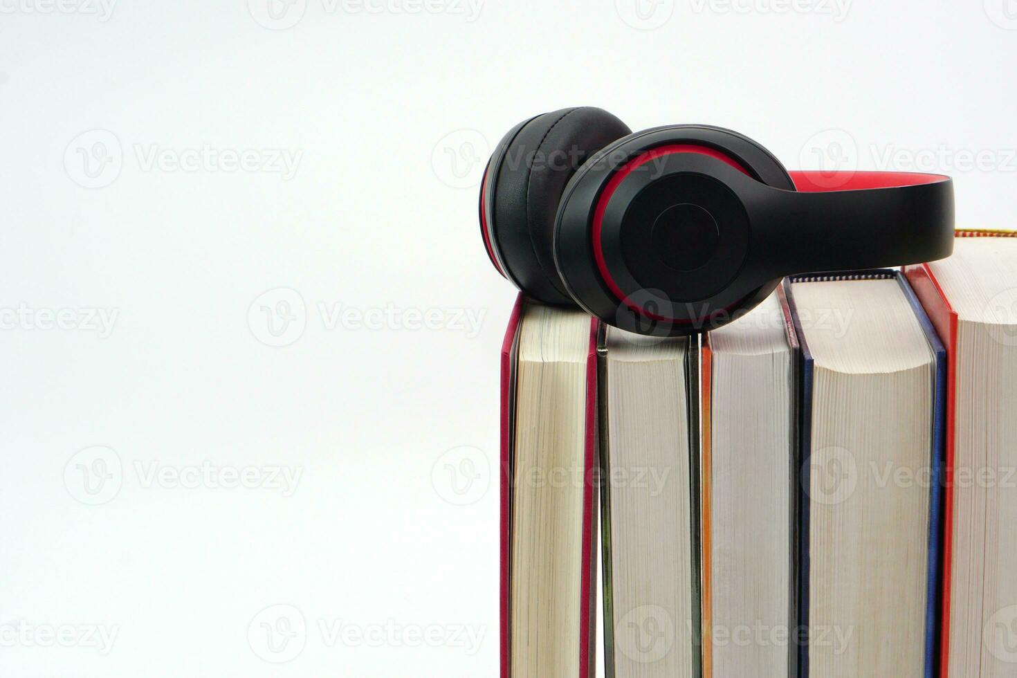 The headphones placed on top of the lined up books. Knowledge, learning and education concept. photo