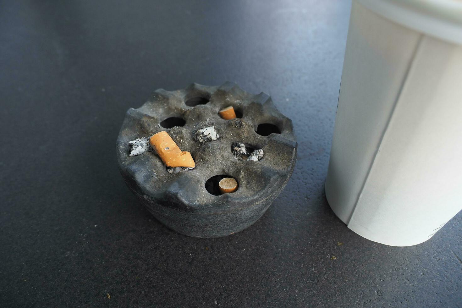 Close up burning cigarette in ashtray on table photo