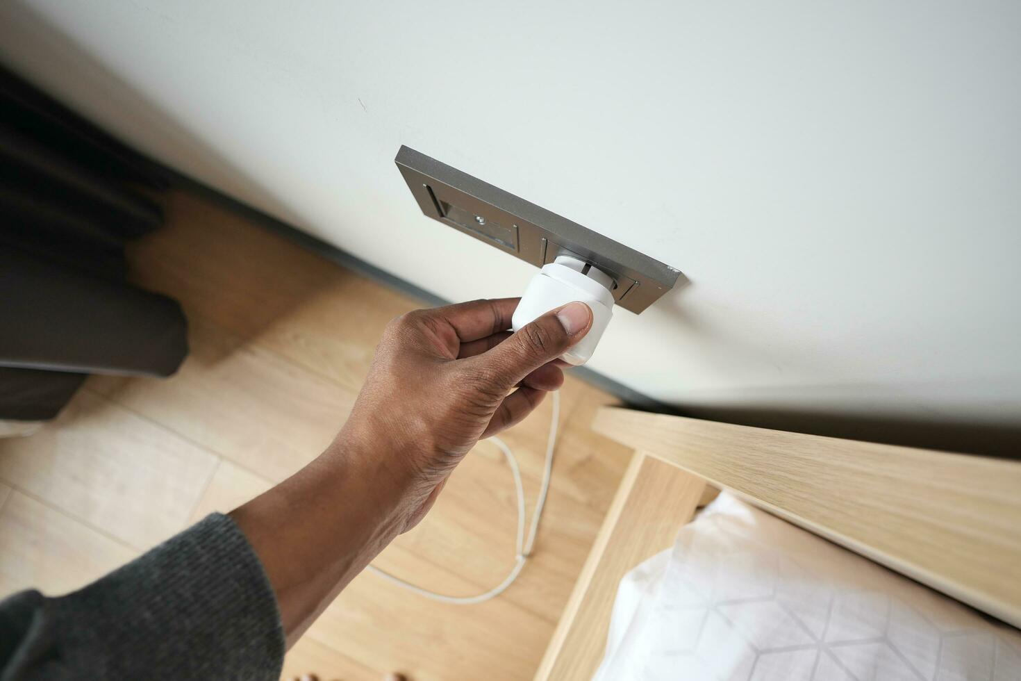 white color power cord cable plugged into wall photo