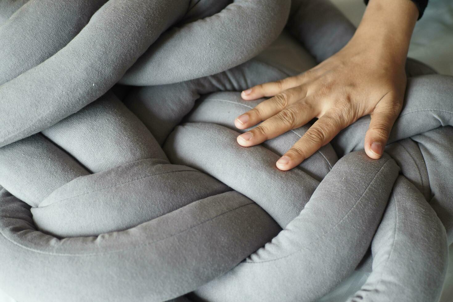 mujer mano terminado un gris color almohada en blanco cama foto