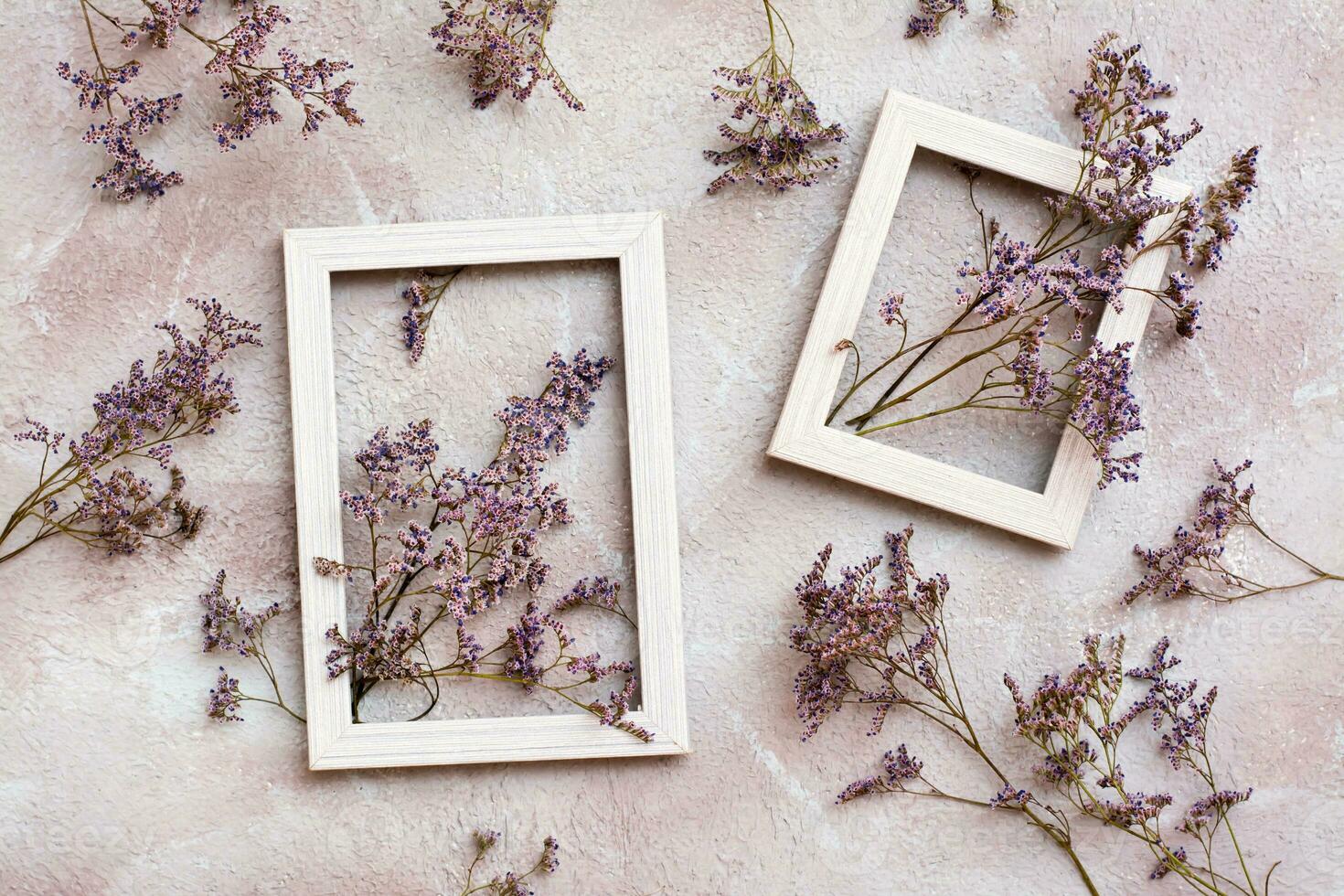 seco púrpura flores en dos de madera blanco marcos y siguiente a ellos en un texturizado antecedentes. romántico saludo Clásico tarjeta. parte superior ver foto