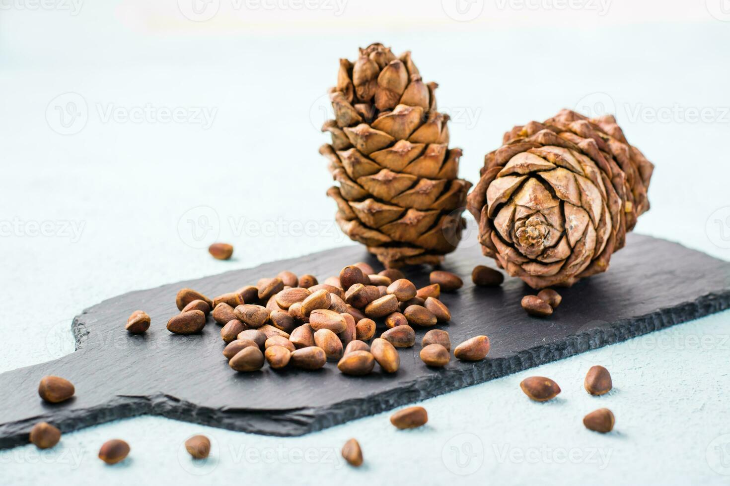 Unshelled pine nuts and cones on a slate board. Gifts of Siberia. Detox and cure for insomnia. Healthy vitamin nutrition photo