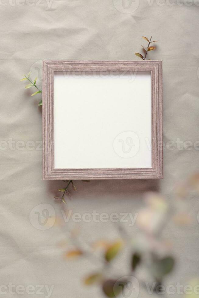 Mockup blank photo frame and branches on green cotton fabric top and vertical view