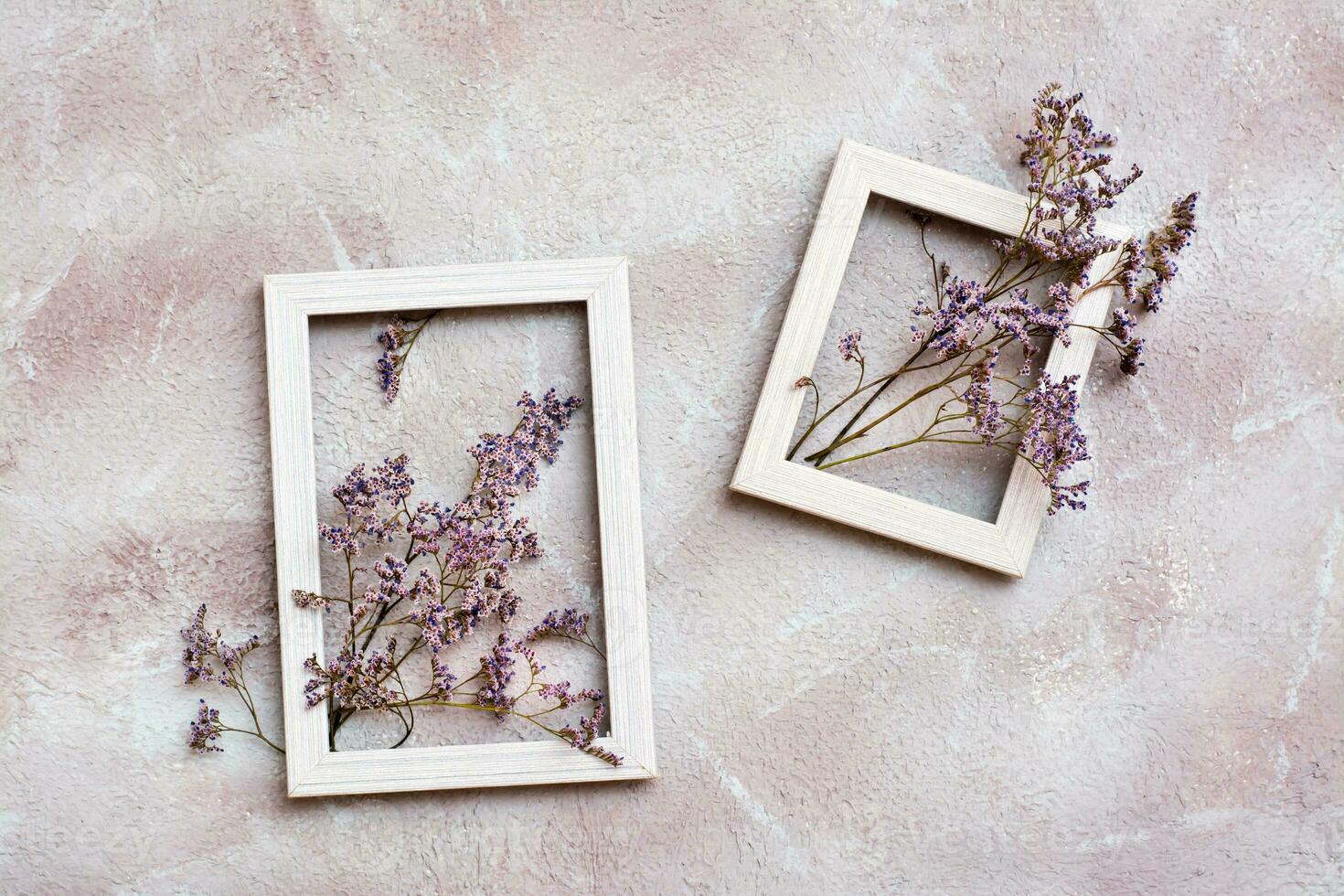 Dry purple flowers in two wooden white frames on a textured background. Romantic greeting vintage card. Top view photo