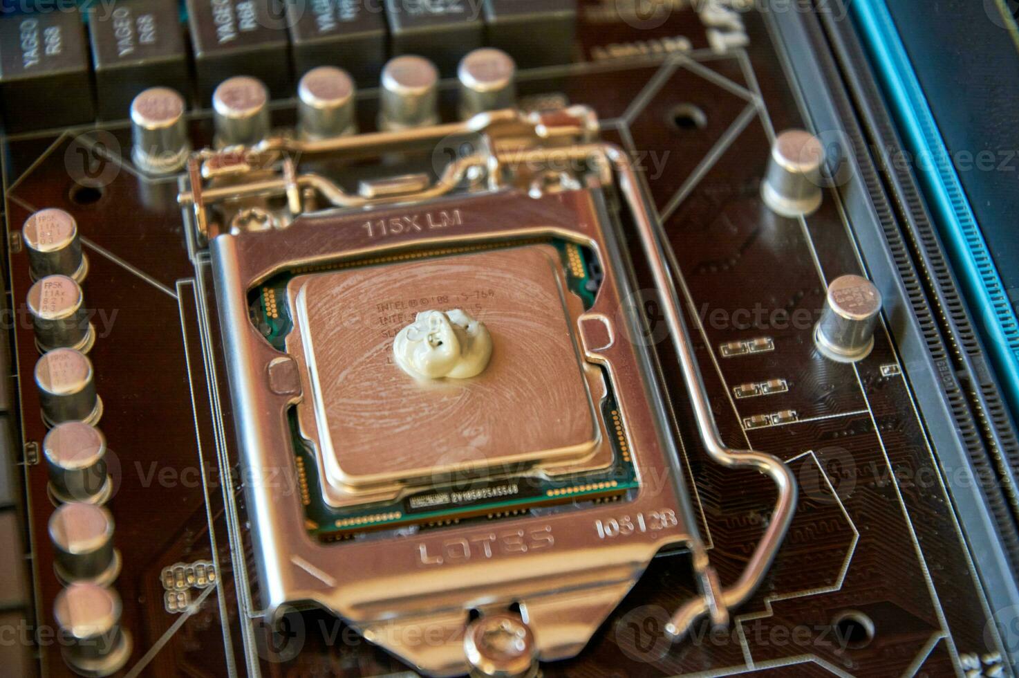 applying thermal paste to the central processor of the motherboard close up photo