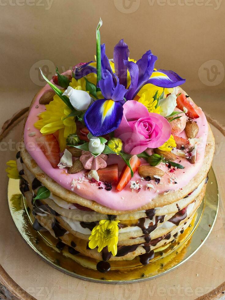 Shot of Milkygirl cake made of white cream with chocolate icing, decorated with flowers and berries photo
