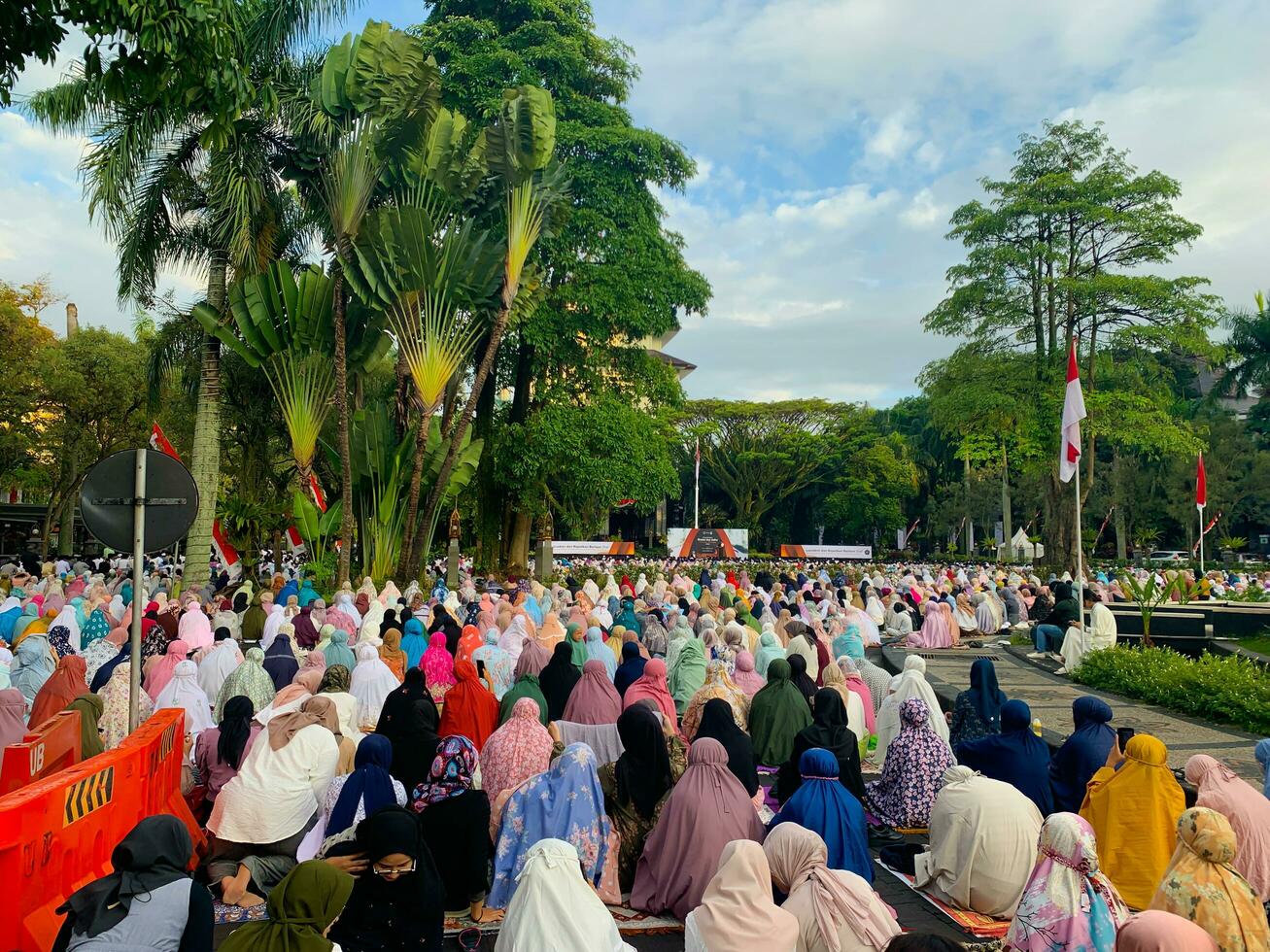 sholat idul fitri. indonesian muslim community are doing eid al fitr prayer in outdoor area. sholat idul adha in college field with words means independent college photo