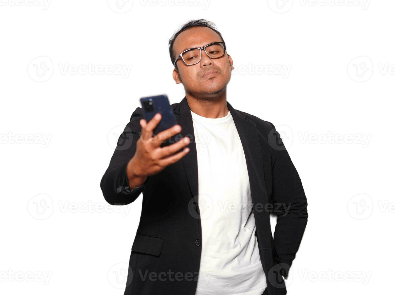emocionado asiático hombre con lentes vistiendo negro traje enojado mientras participación su teléfono, aislado por blanco antecedentes foto