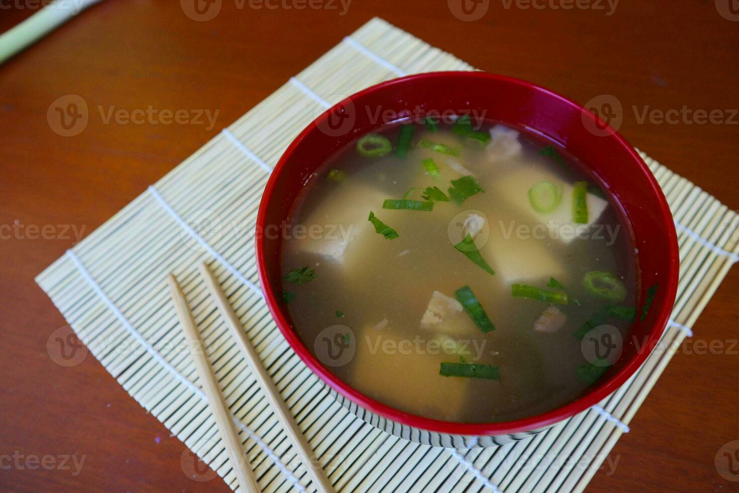 miso soup or Japanese miso soup in bowl on the table. Japanese cuisine in the form of soup with dashi ingredients, tofu, seafood, vegetables, and topped with miso to taste photo