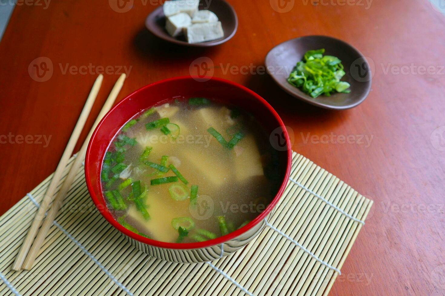 miso soup or Japanese miso soup in bowl on the table. Japanese cuisine in the form of soup with dashi ingredients, tofu, seafood, vegetables, and topped with miso to taste photo